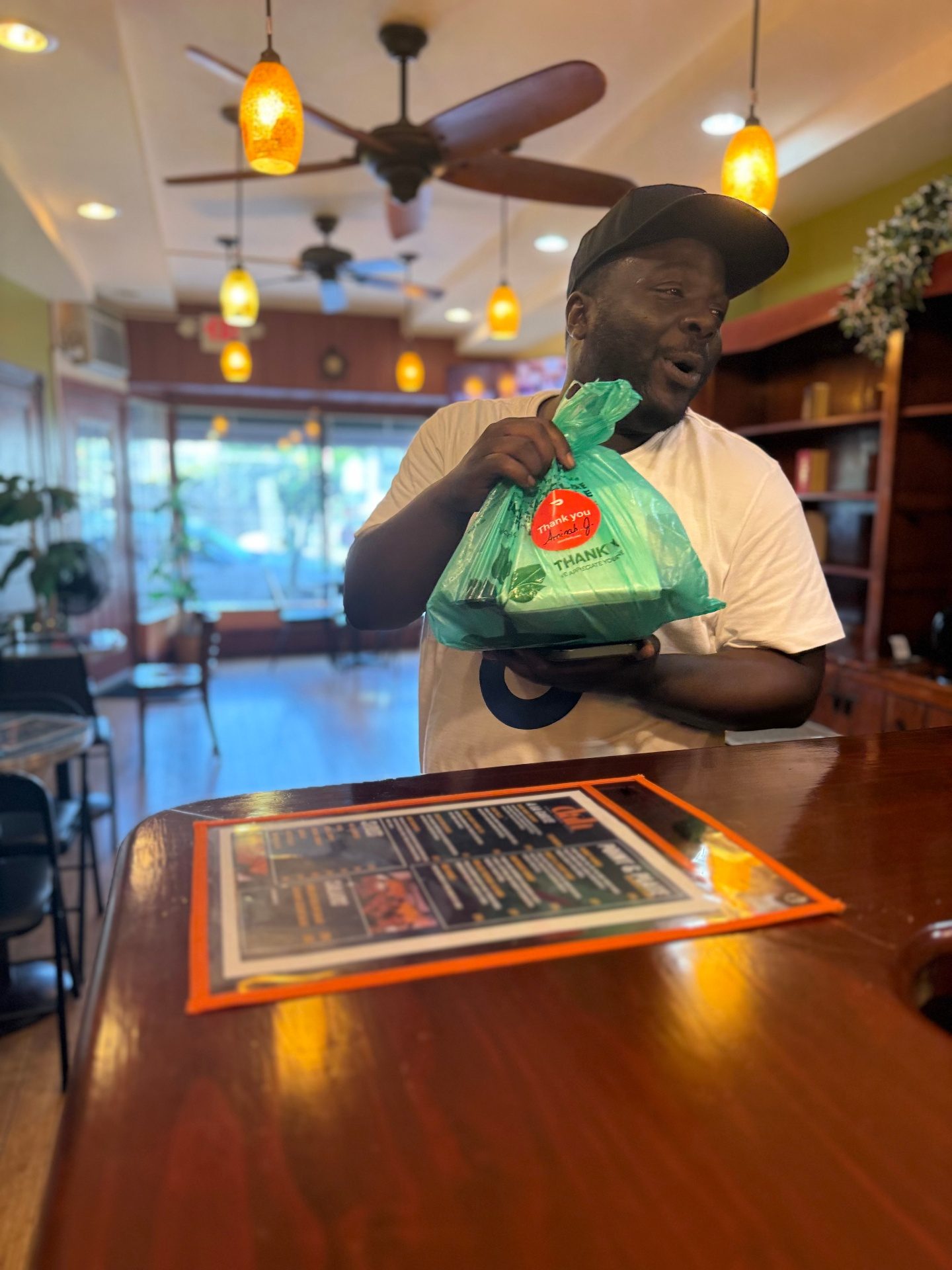 Dah's team member handing off a hot takeout order